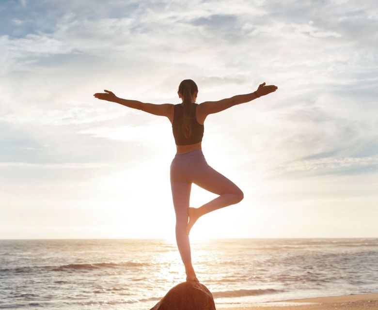 Woman Doing Yoga On Rock