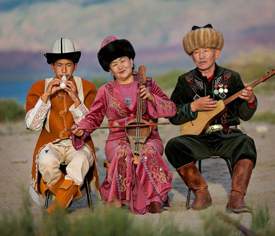 Three people sitting playing instruments