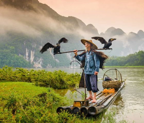 Man on raft with birds