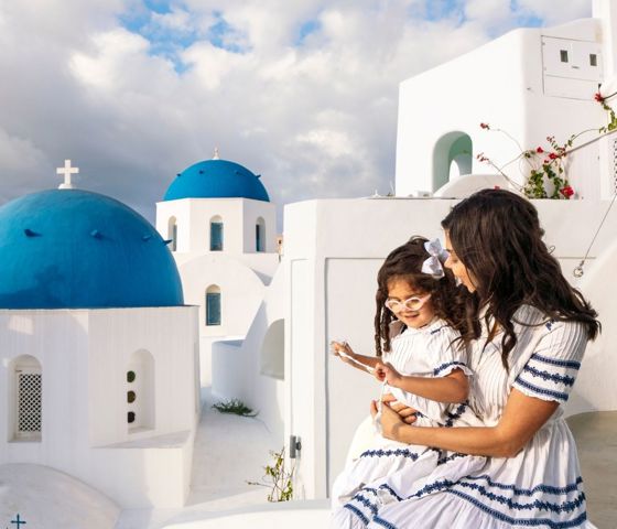 Santorini, Greece, woman on balcony holding little girl