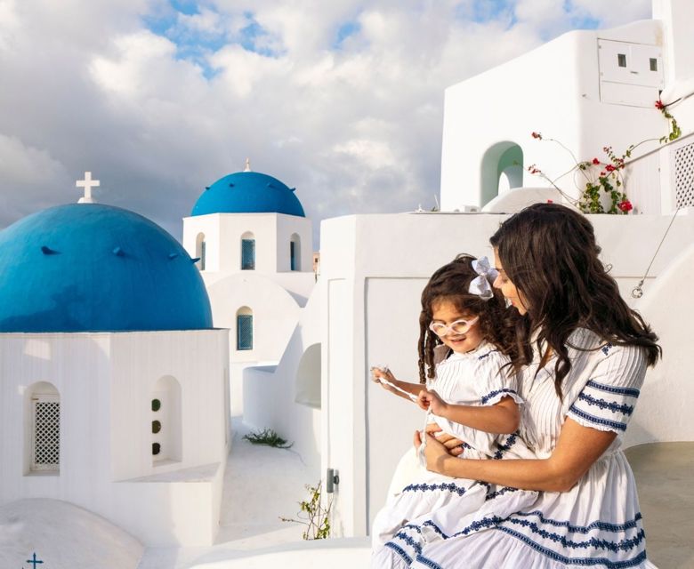 Santorini, Greece, woman on balcony holding little girl