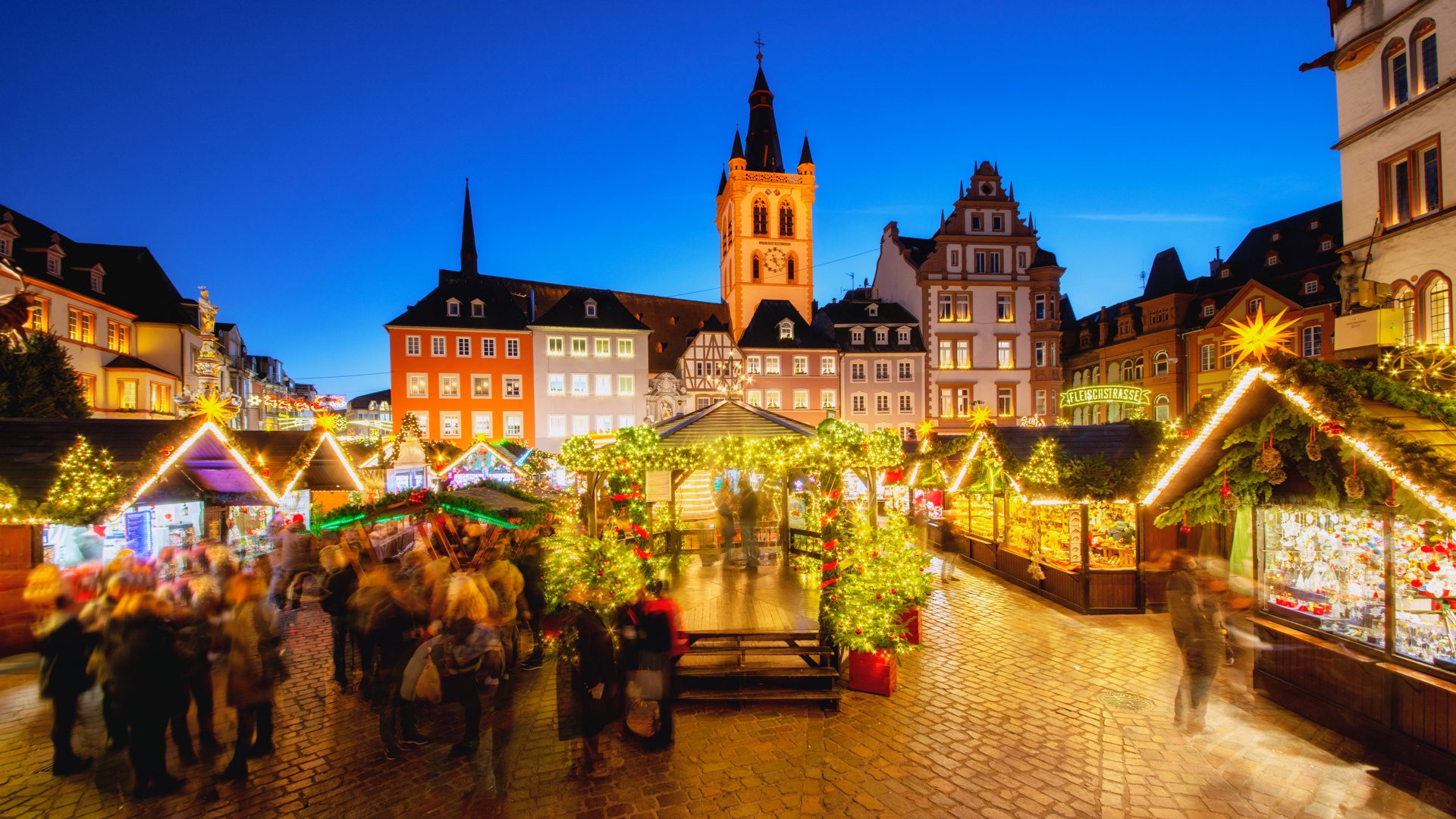 Festival Christmas markets twinkle at night.