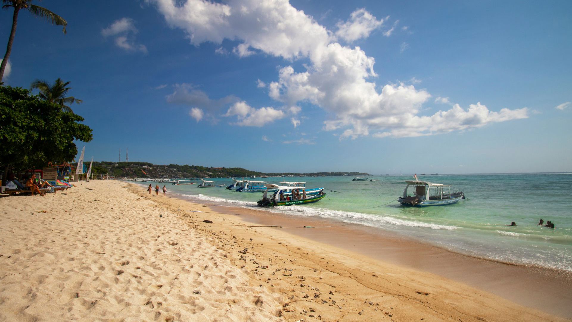 Boats docking on a beach on a sunny day in Bali. Image credit: Unsplash/Tarryn Myburgh