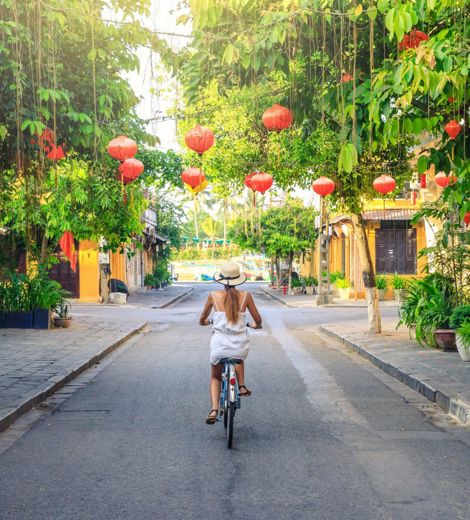 Woman riding biking through Hoi An streets
