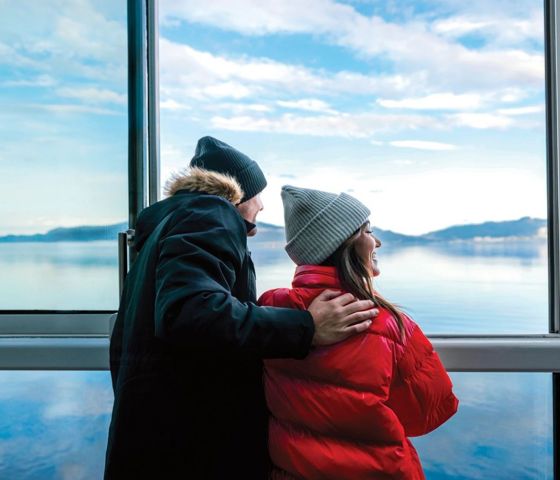 Ovation of the Seas, couple at windows, wearing winter coats